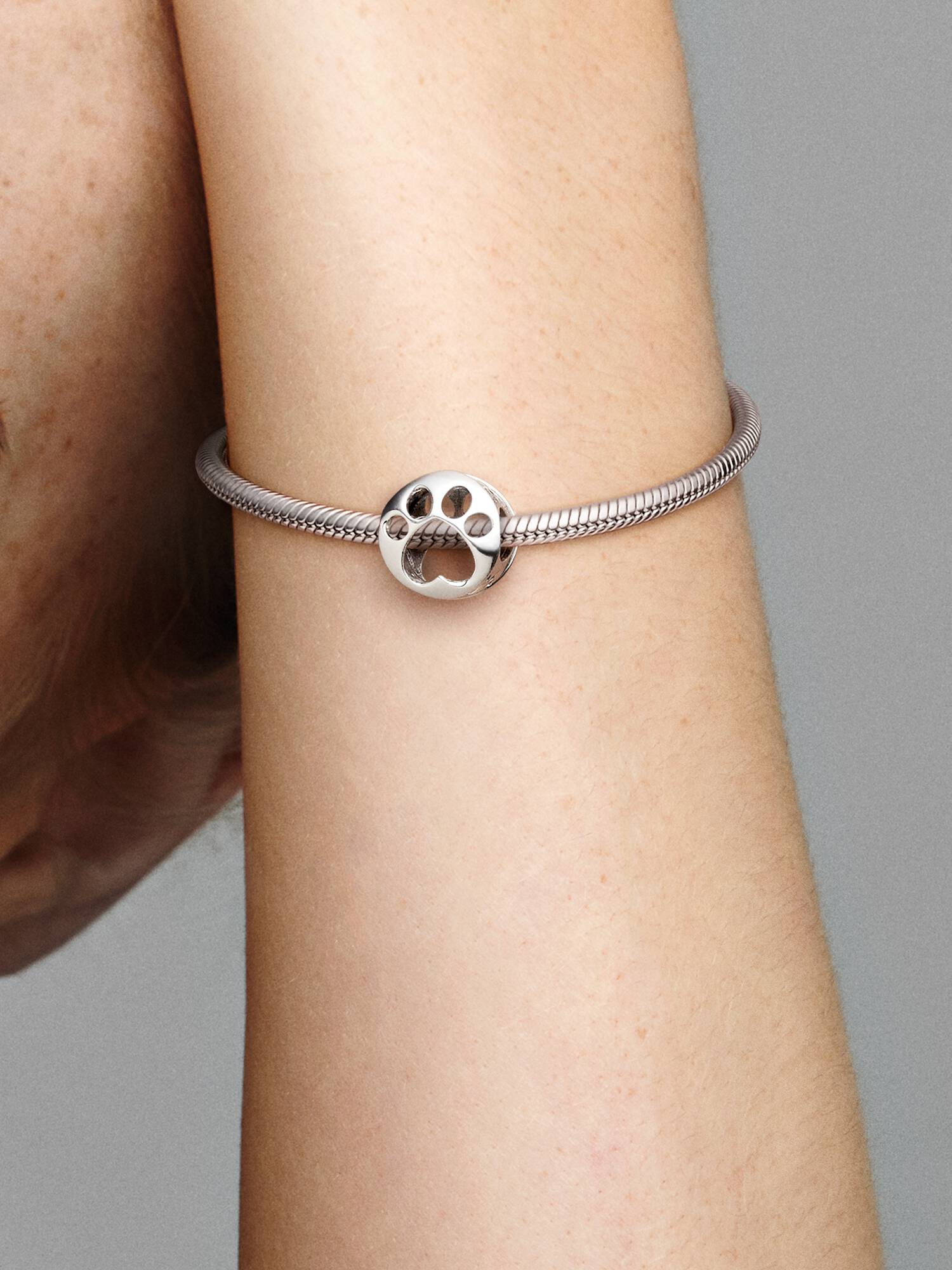 Charm vazado com impressão de patinha.