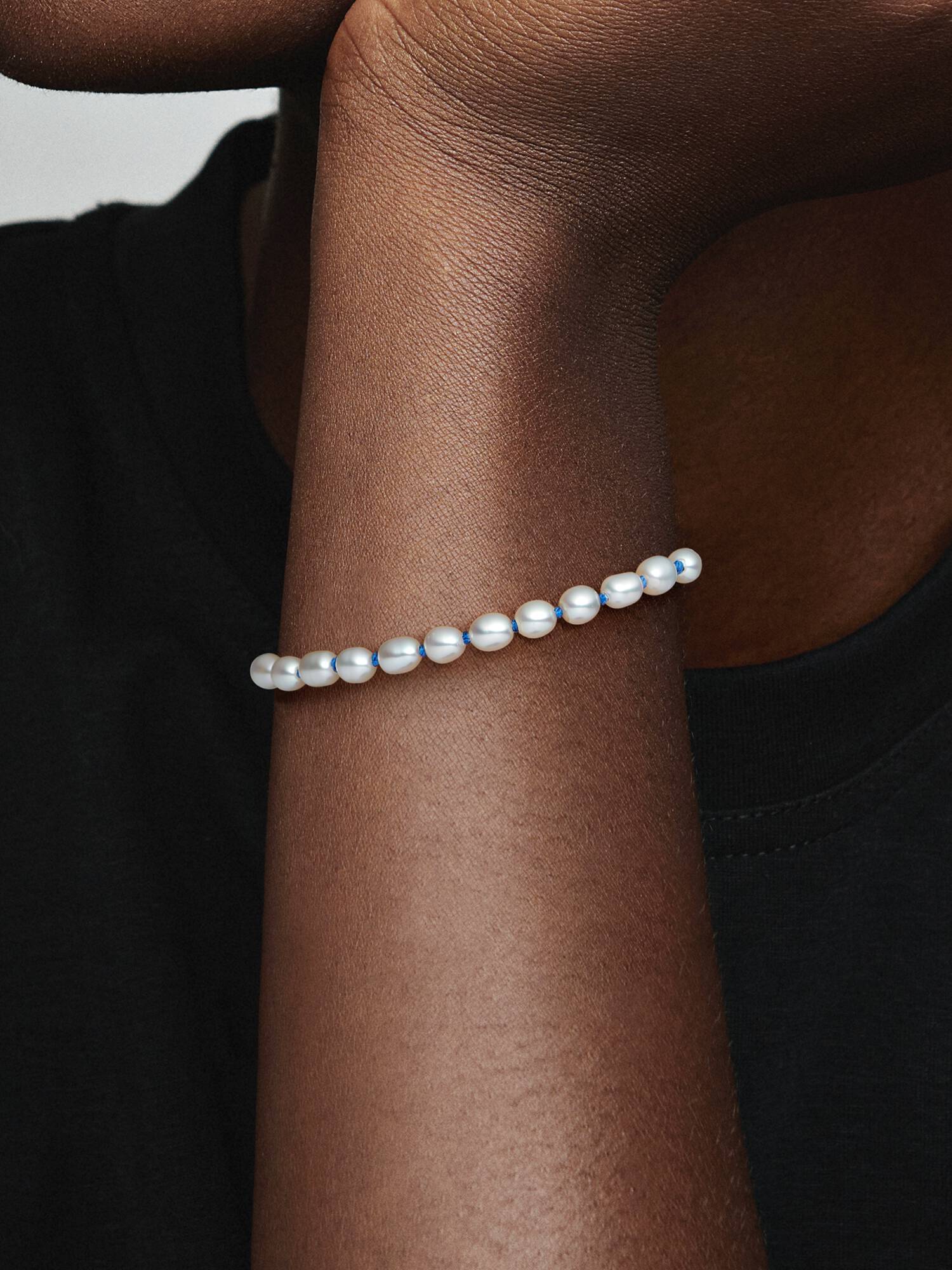 Sterling silver bracelet with white treated freshwater cultured pearl and blue cord