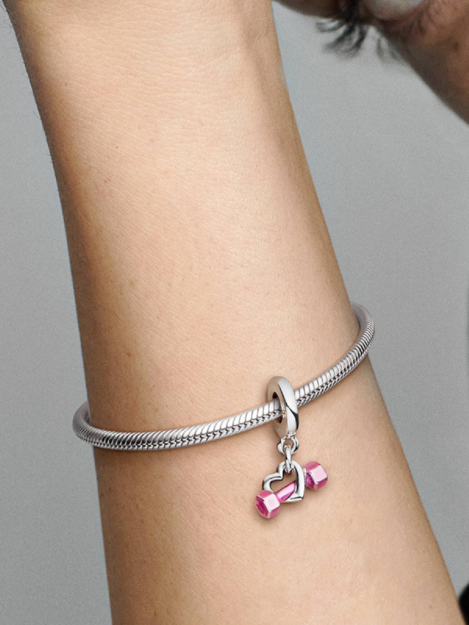 Charm pendente com haltere e coração.